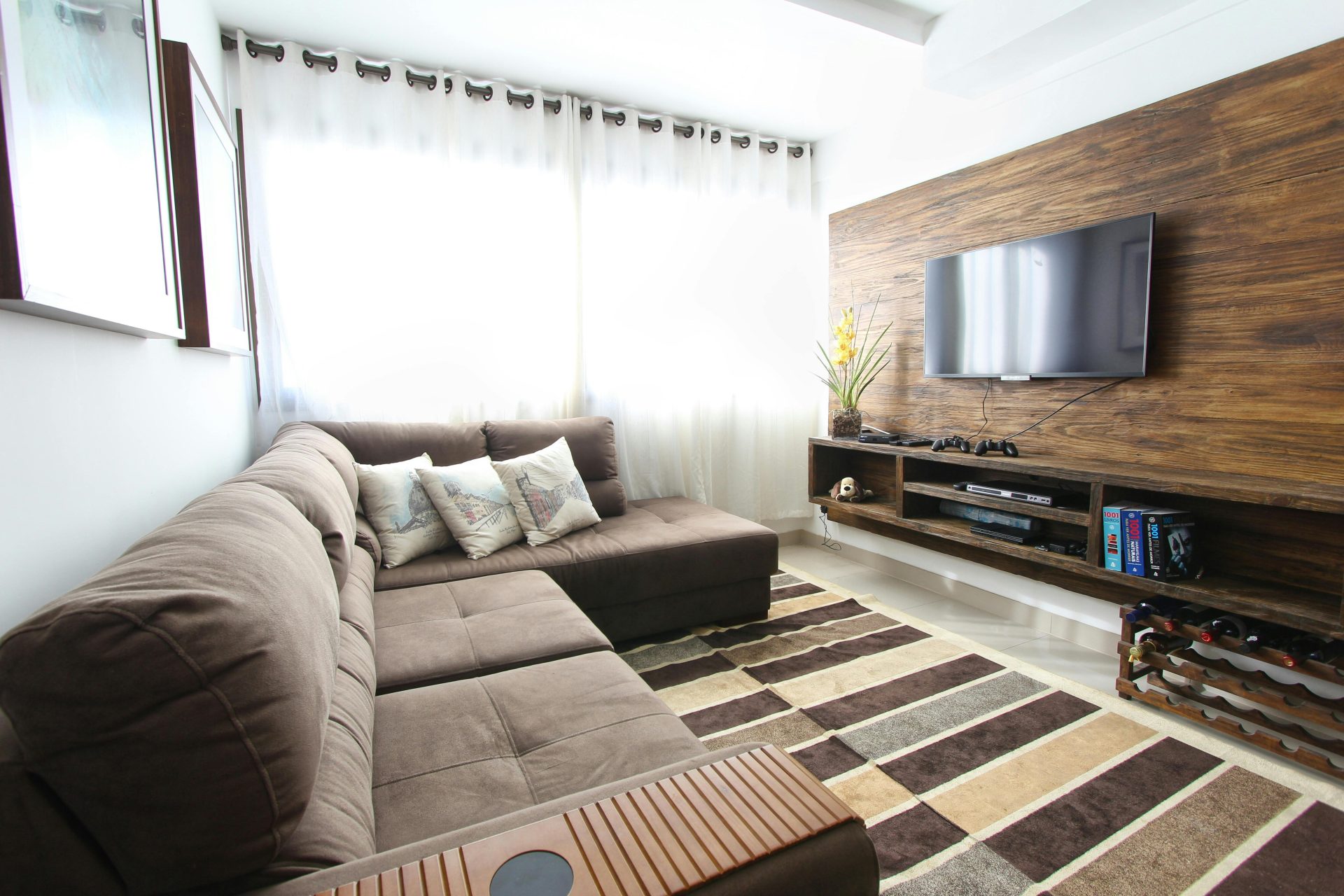Stylish modern living room featuring a brown sofa, wall-mounted TV, and interior decor.
